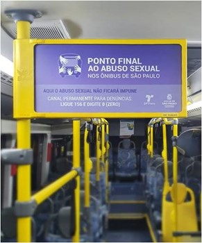 Foto interna de um ônibus dando destaque para um banner que divulga a campanha Ponto Final ao Abuso Sexual nos ônibus de São Paulo