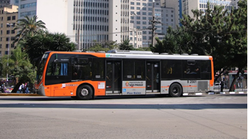 #pracegover lateral de ônibus perto de árvores e prédios