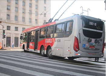 #pracegover traseira do ônibus da linha 2002 perto de prédio