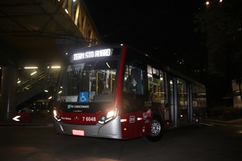 #pracegover ônibus da área sete entrando em terminal a noite com o letreiro terminal santo amaro