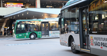 #pracegover dois ônibus da via sudeste um prata e um verde