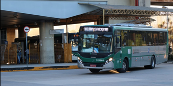 #pracegover ônibus com letreiro escrito term sacomã dentro de terminal perto de grades amarelas