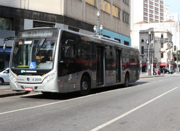 #PraCegoVer: Imagem de um ônibus de cor prateada, em operação diurna, com letreiro indicando destino ao Pq. da Lapa