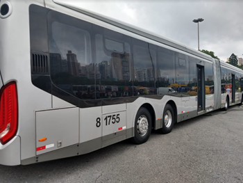 #PraCegoVer: Imagem de um ônibus de cor prateada, da área 8, que atende a Zona sudoeste da cidade. O veículo está estacionado em uma garagem