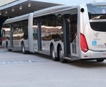 #pracegover ônibus da área cinco prata entrando em terminal perto de faixas indicadoras de km/h