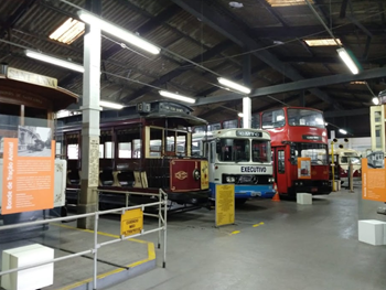 #pracegover imagem de bonde ônibus da CMTC e fofão (ônibus de dois andares) dentro do museu