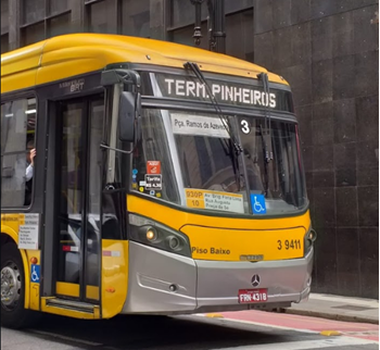#PraCegoVer: Imagem de um ônibus de cor amarela, em operação pelo centro da cidade, com letreiro indicando destino ao Terminal Pinheiros, na Zona Sul