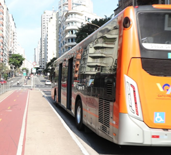 #PraCegoVer: Imagem de um ônibus de cor laranja, no momento em que está em operação. O ônibus atende a zona Sudoeste da cidade